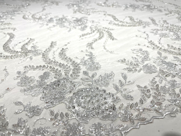 White flowers embroider and heavy beaded on a mesh lace fabric-sold by the yard.