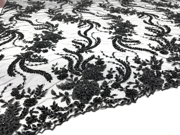 Black flowers embroider and heavy beaded on a mesh lace fabric-sold by the yard.